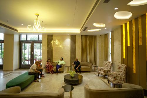 a group of people sitting in a lobby at Hotel Krinoscco in Ayodhya