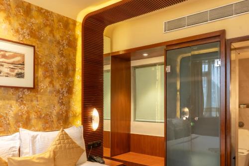a room with a bed and a glass door at Regenta Orkos Kolkata by Royal Orchid Hotels Limited in Kolkata