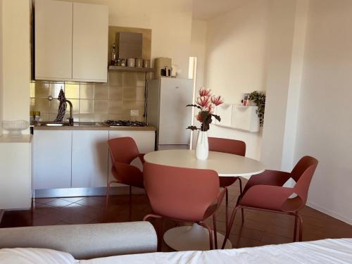 a kitchen with a table and chairs with a vase of flowers at DaMa s Apartment on the beach in Giardini Naxos
