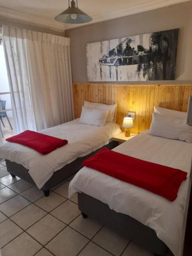 two beds sitting next to each other in a room at Protea Park Self Catering Guesthouse in Rustenburg