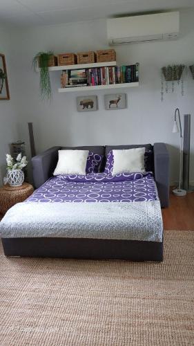 a bed in a room with a purple bedspread at Bispgården Paradis in Bispgården