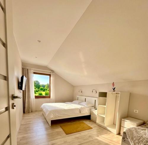 a bedroom with two beds and a window at Domo Vila in Druskininkai