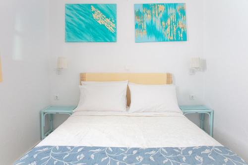 a bedroom with a bed with two pictures on the wall at Ibiscus down town location Myconos in Megali Ammos
