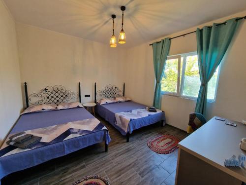 a bedroom with two beds and a window at Porto Lima in Limanu