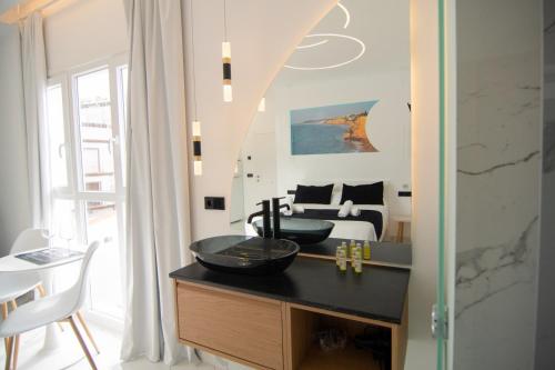 a bathroom with a sink and a bedroom with a bed at Apartamentos Alsa in Conil de la Frontera