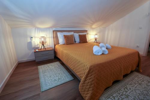 a bedroom with a large bed with two lamps on it at Casa Alvega - 50m do Rio - Piscina com Hidromassagem in Alvega