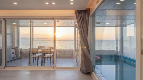 a dining room with a view of the ocean at Pohang Etoile Poolvilla in Pohang