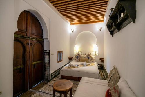 a bedroom with a bed and a large wooden door at Dar Ras Jnan -luxury stay - rooftop in Oulad Akkou