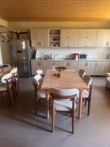 a kitchen with a wooden table and chairs and a refrigerator at Guesthouse Lasili in Mestia in Mestia
