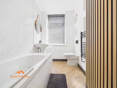 a bathroom with a tub and a sink and a toilet at Cosy Colne Cottage in Colne