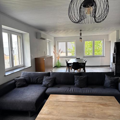 a living room with a couch and a table at Le Gîte du Trieux - Berzée in Berzée