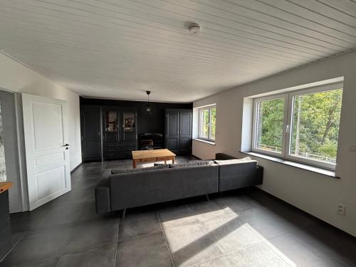 a living room with a couch and a table at Le Gîte du Trieux - Berzée in Berzée