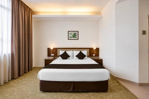 ein Hotelzimmer mit einem großen Bett und Vorhängen in der Unterkunft Sunday Near Gerbang Malam Ipoh Formerly Seemsoon in Ipoh