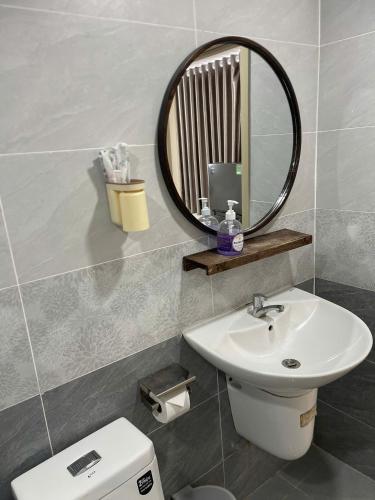 a bathroom with a sink and a mirror and a toilet at Lunar Stay HCM in Ho Chi Minh City