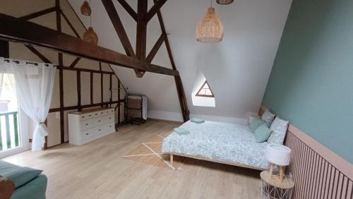 a bedroom with a bed in the corner of a room at La grange de l'épine in Forges-la-Forêt