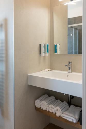 a bathroom with a sink and a mirror and towels at DB Residence Luxury Stay in Noventa di Piave