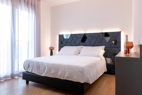 a bedroom with a large bed with a black headboard at DB Residence Luxury Stay in Noventa di Piave
