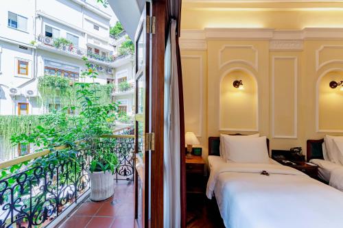 a bedroom with a bed and a balcony at Hotel Majestic Saigon in Ho Chi Minh City
