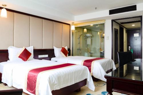 a hotel room with two beds and a shower at New World Hotel in Guangzhou