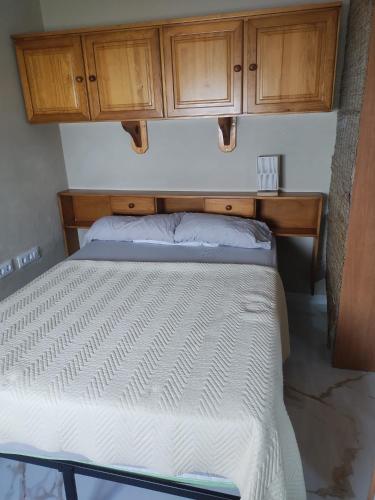 a bed in a room with wooden cabinets at Casa Colón en la mancha in Herencia