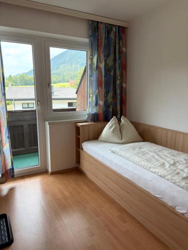 a bedroom with a bed and a large window at Appartment Lärchenalm in Sankt Martin am Tennengebirge