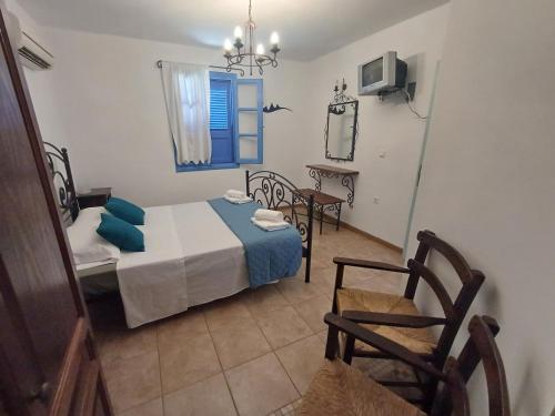 a small bedroom with a bed and a chair at Meraki lipsi apartment in Leipsoi