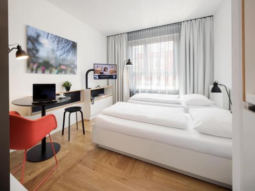 a bedroom with two beds and a desk with a computer at smartments Wien Hauptbahnhof - Serviced Apartments in Vienna