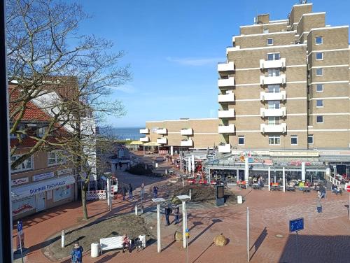 a large building in a city with people walking around at Haus Schildt, FeWo 1 in Duhnen