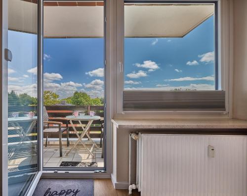 a window with a view of a balcony with a table at Haus Schildt, FeWo 1 in Duhnen