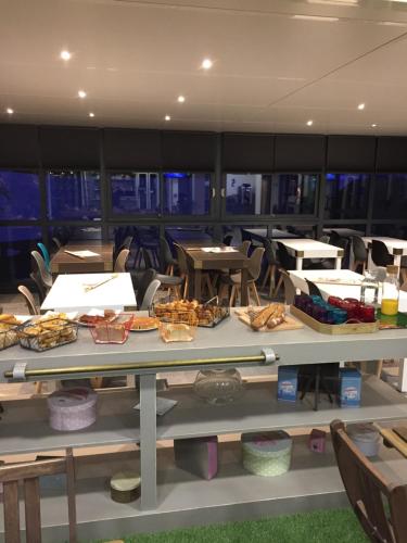 una mesa con comida en una habitación con sillas en Kyriad Direct La Rochelle Aytré, en Aytré