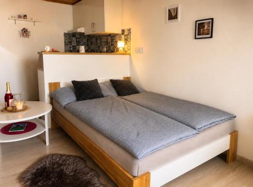 a bed in the corner of a room with a table at U krbu in Jindřichovice