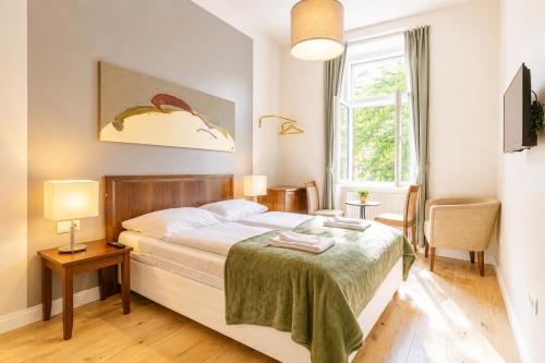 a bedroom with a large bed and a window at 1 Aprt & 5 Stylish Hotel Rooms, Comfort & Convenience Combined in Vienna