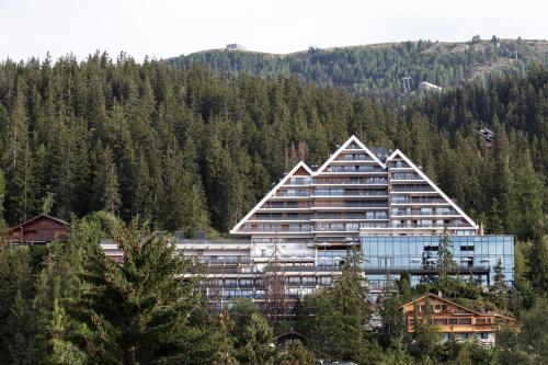 a large building on the side of a mountain at Crans Ambassador in Crans-Montana