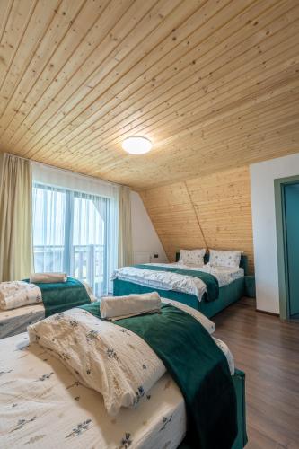 a room with three beds and a wooden ceiling at Panoramic Hill Jina in Jina