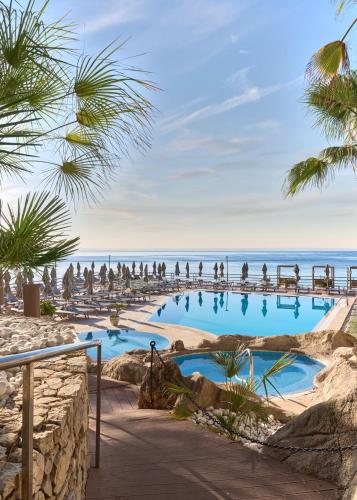 a swimming pool on the beach with palm trees at Barceló Illetas Albatros - Adults Only in Illetas