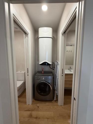 a bathroom with a washing machine and a sink at El Gabal in Soto de la Marina