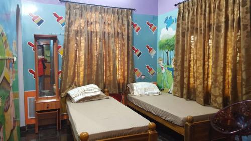 a bedroom with two beds and a wall with shoes on it at GokStay in Chennai