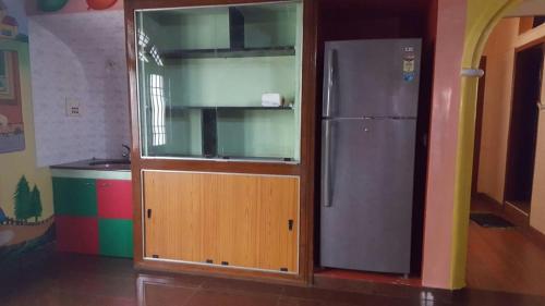 a kitchen with a refrigerator and a wooden door at GokStay in Chennai