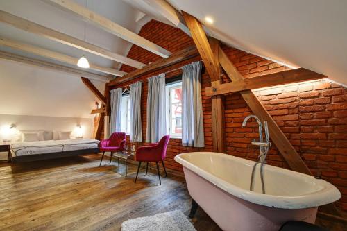a bathroom with a bath tub and a bedroom at Statek Salajna in Salajna