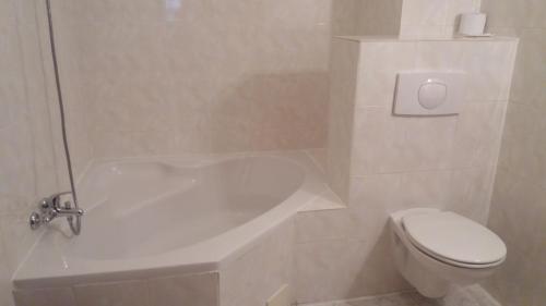 a bathroom with a white tub and a toilet at Hotel Zámeček Pod Hradem Starý Jičín 111 in Starý Jičín