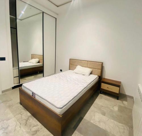 a bedroom with a bed and a large mirror at Résidence Mariem Tantana in Akouda