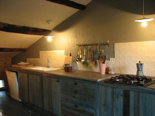 a kitchen with a stove and a counter top at Les Granges in Bouvières