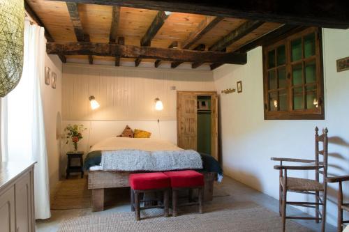 a bedroom with a bed and two red chairs at Les Granges in Bouvières