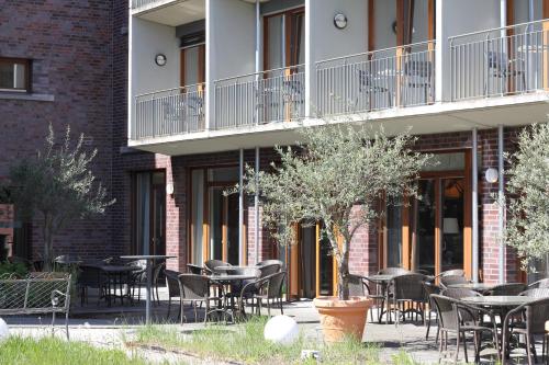 a group of tables and chairs in front of a building at Hotel Begardenhof in Cologne