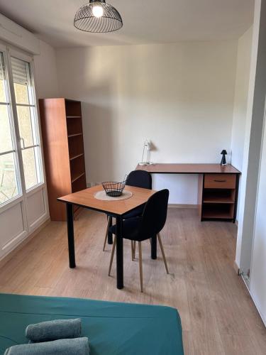 a living room with a table and a desk at Studio 20m2 avec balcon in Corte