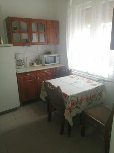 a small kitchen with a table and a microwave at Tapolca Centrum-Tapolca Szíve Apartmanok in Tapolca
