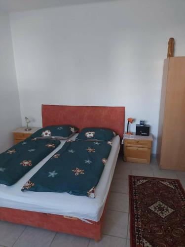 a bed with four pillows on it in a bedroom at Tapolca Centrum-Tapolca Szíve Apartmanok in Tapolca