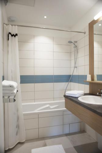 a bathroom with a tub and a sink and a shower at Chambres de la Bastide des Joncas in Martigues