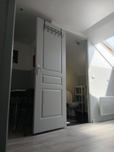 an open white door in a room with a window at Le Trait d'union - Studio César, 2éme Étage in Romilly-sur-Seine