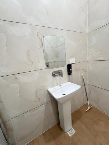 a bathroom with a sink and a mirror on a wall at Norway Residency in Jagādhri